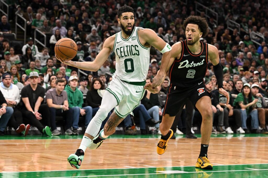 Jayson Tatum attacking the paint against Pistons star, Cade Cunningham.